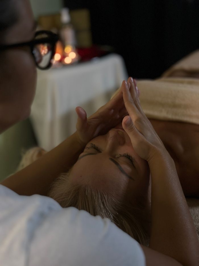 A soothing head massage in a tranquil spa setting with aromatherapy candles.